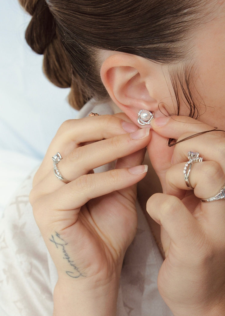 woman wearing earrings getting ready to go out